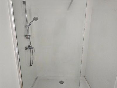 Detail of the shower with glass screen and steel fittings in a modern bathroom.