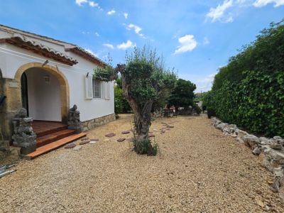Villa entrance featuring gravel, terracotta steps, and sandstone archway.