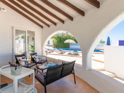 Covered terrace with pool views and exposed wood beams.