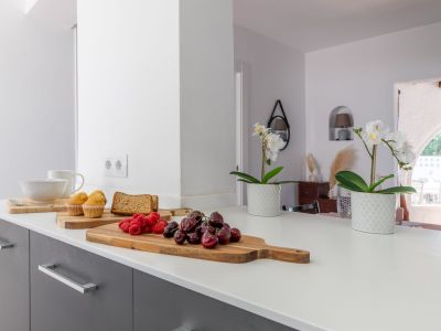 Kitchen counter detail with fruit and flowers, showcasing a bright, modern design.