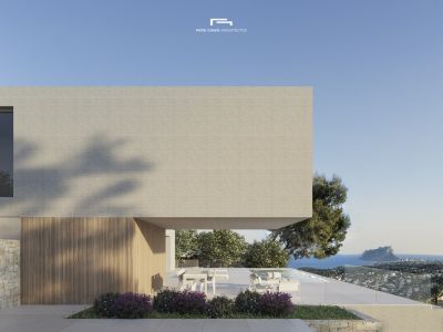 Exterior view of the villa featuring a light brick facade and a terrace overlooking the sea.