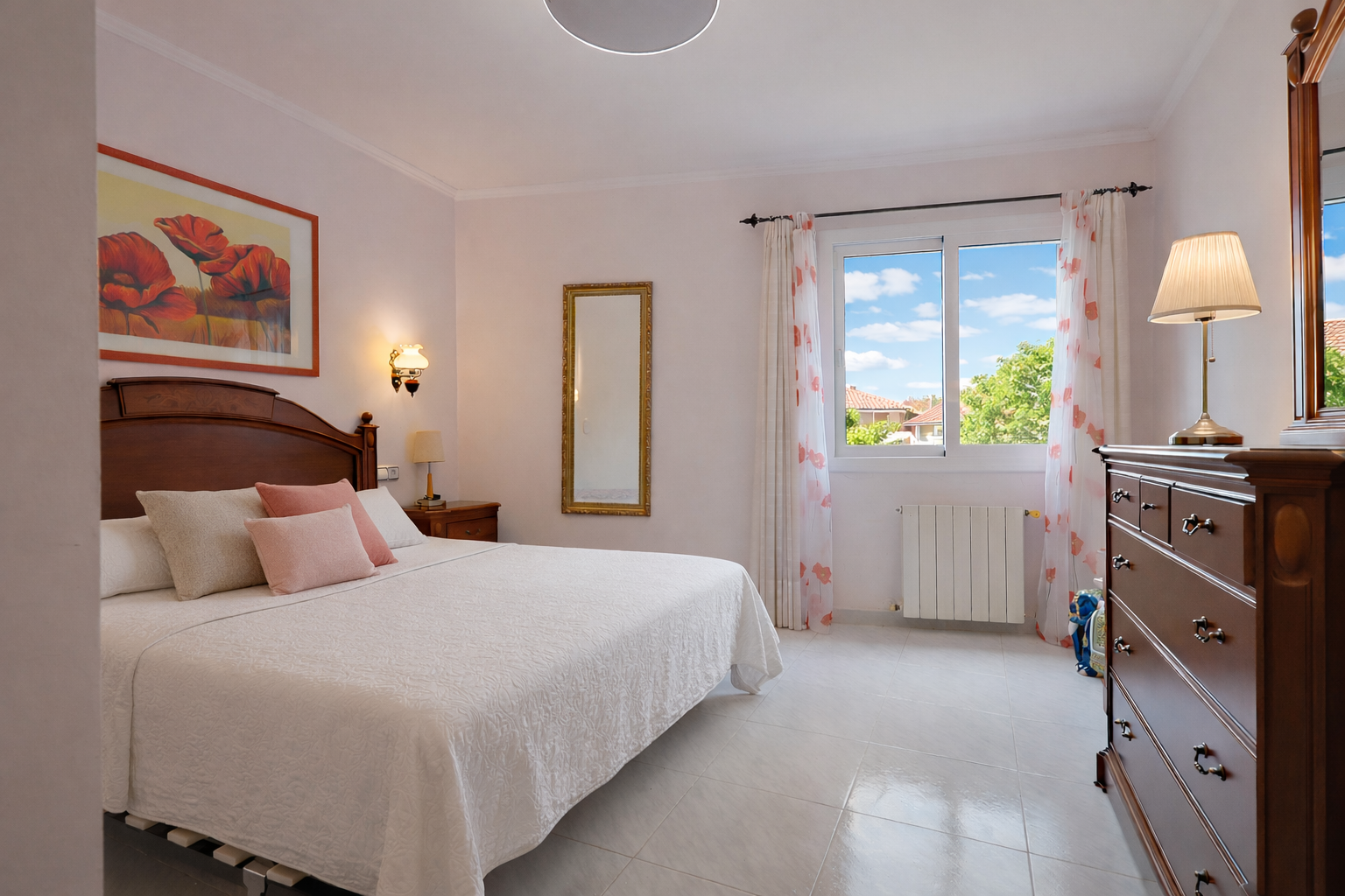 Bright bedroom featuring a wood-framed bed, classic dresser, and exterior views.