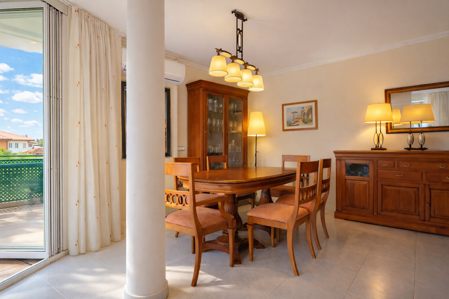 Bright dining room featuring a wooden table, display cabinet, and access to an outdoor terrace.