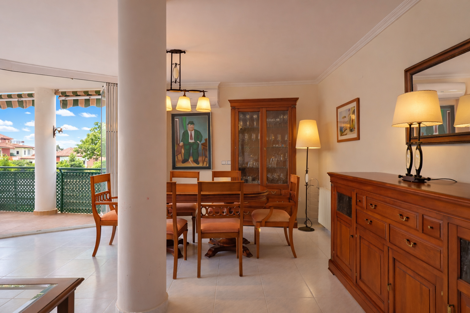 Bright dining room with terrace access. Classic wood furniture and ceramic tile flooring.