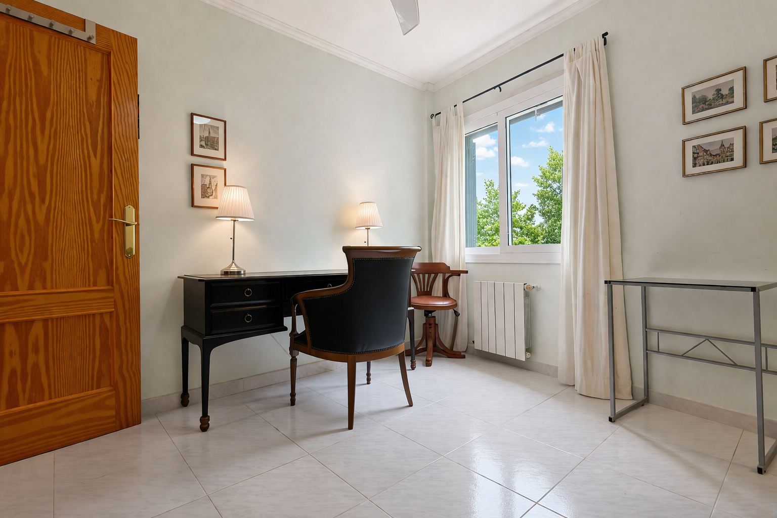 Bright room featuring a classic dark wood desk and upholstered chair, ideal for a study or workspace.