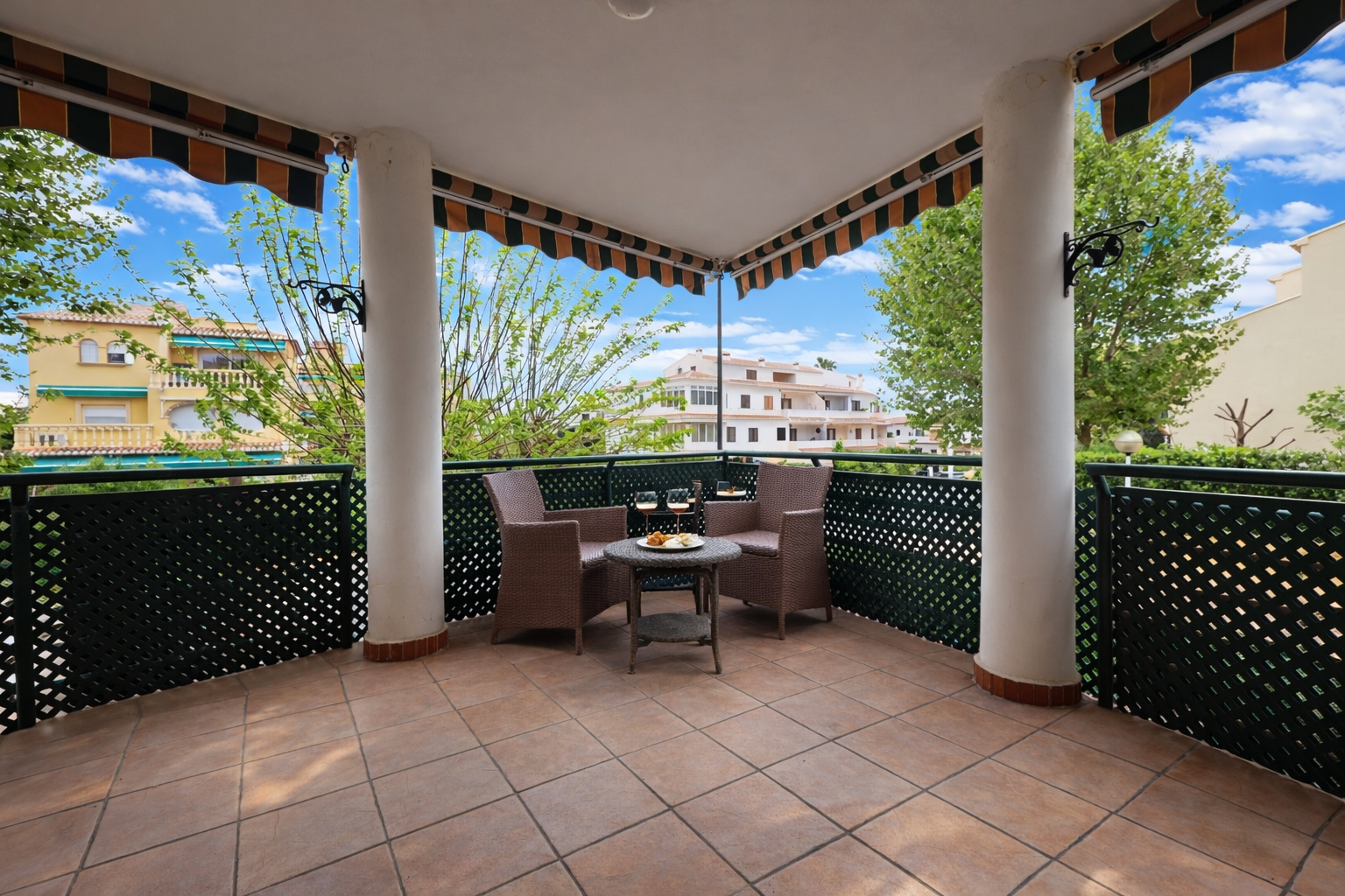 Covered terrace with tile flooring and views of residential buildings.