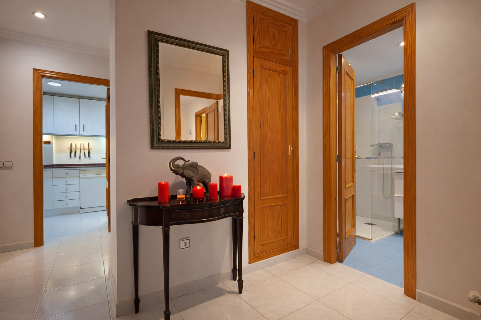 Hallway detail with wood console table, mirror, and bathroom access.