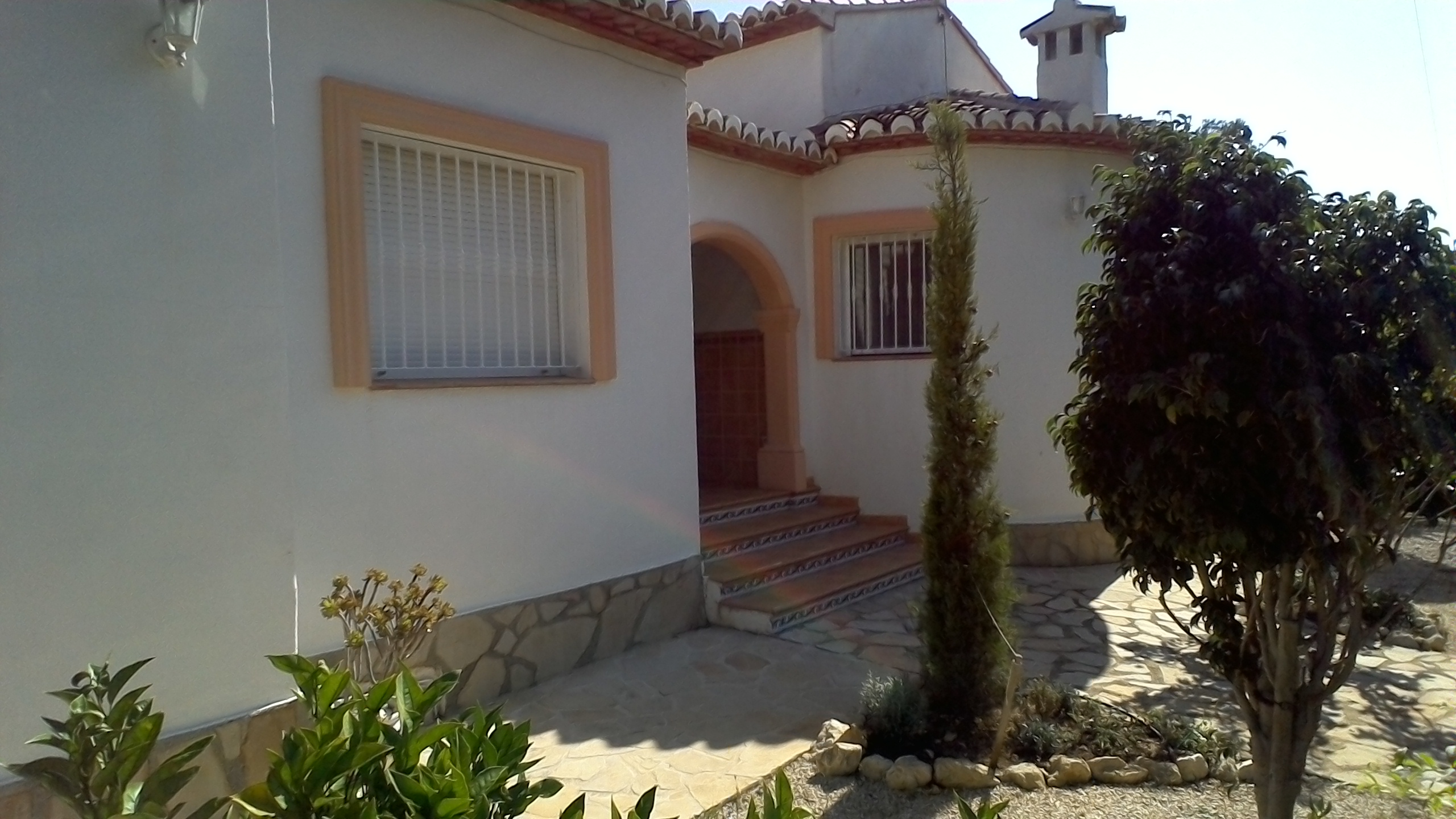 Villa facade featuring stone accents and stepped access with decorative tiles.