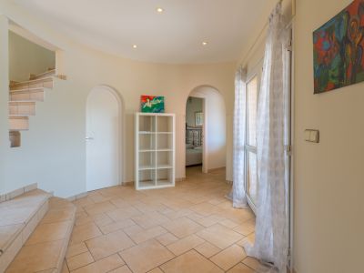 Bright entryway featuring tiled stairs and ceramic flooring.