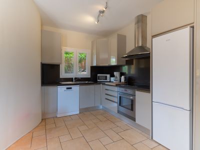 Bright kitchen featuring dark countertops and modern stainless steel appliances.