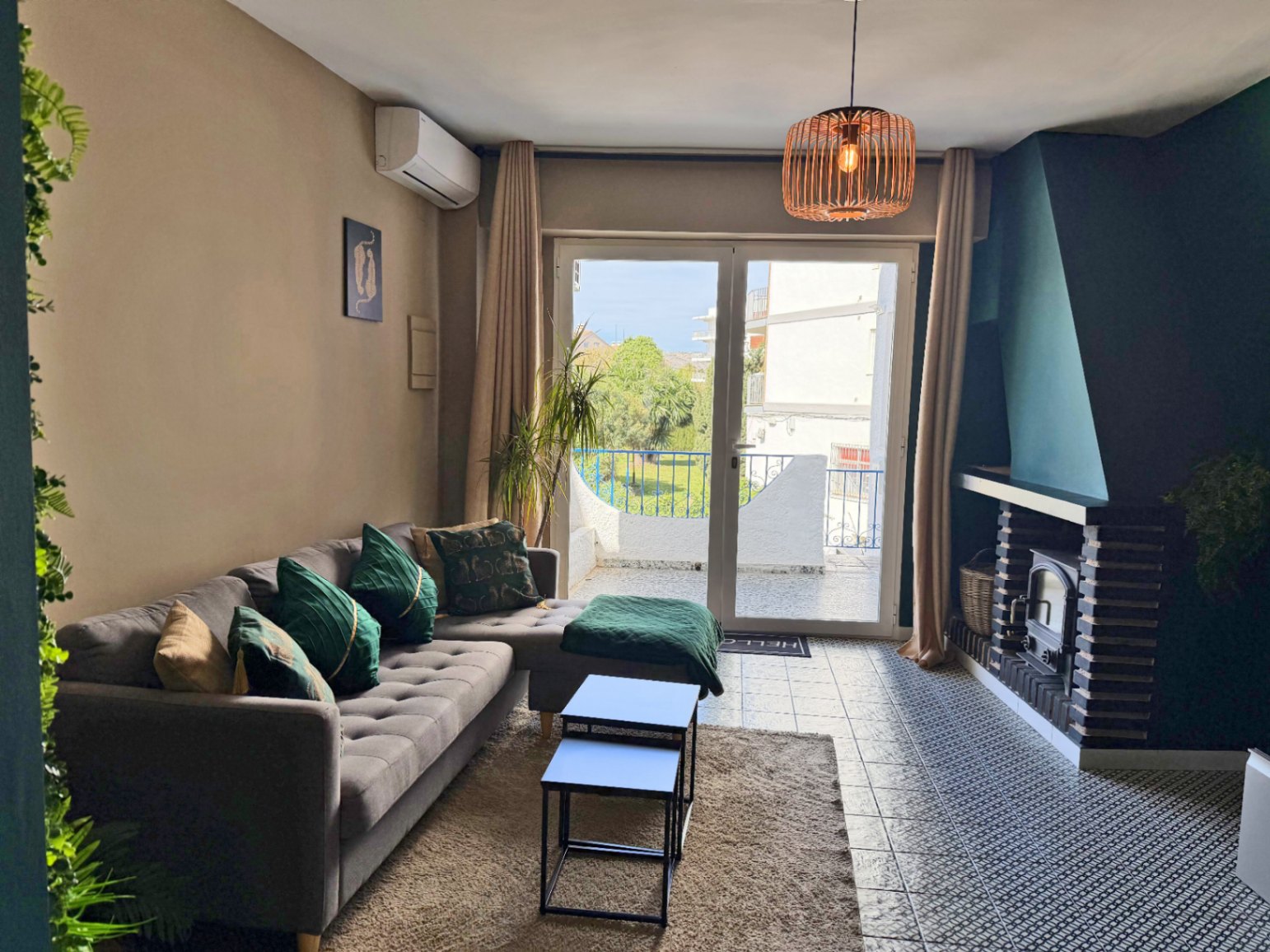 Bright living room with fireplace and terrace access offering outdoor views.