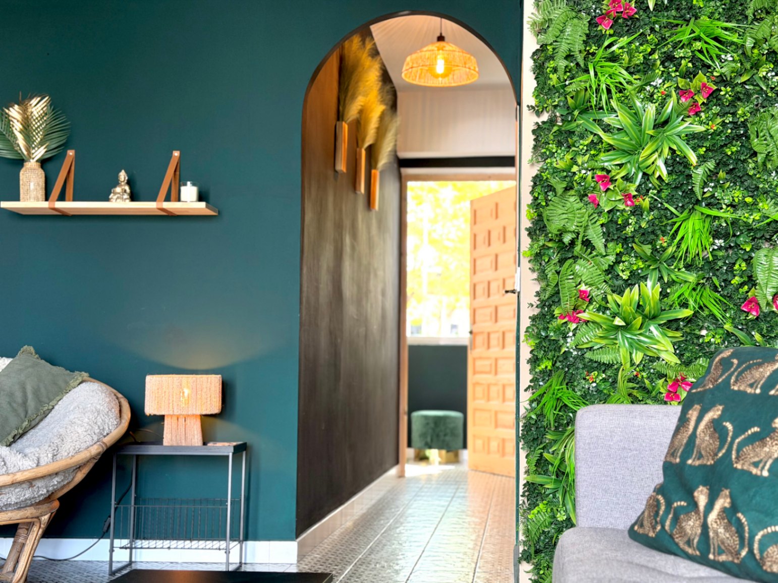 Interior featuring a vertical green wall, decorative archway, and floating shelf on a blue wall.
