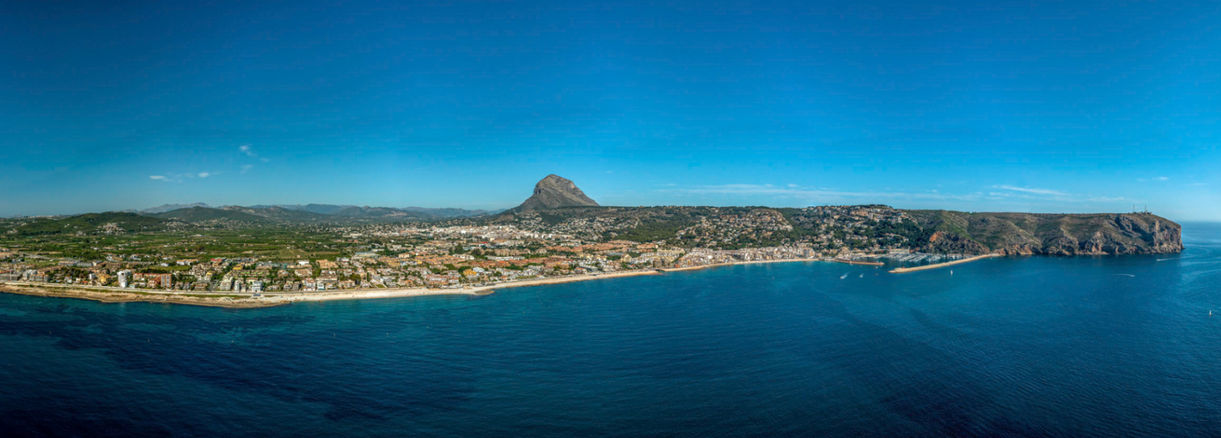 Panoramic view of Jávea, featuring the coastline, Mediterranean Sea, and Montgó mountain in the background.
