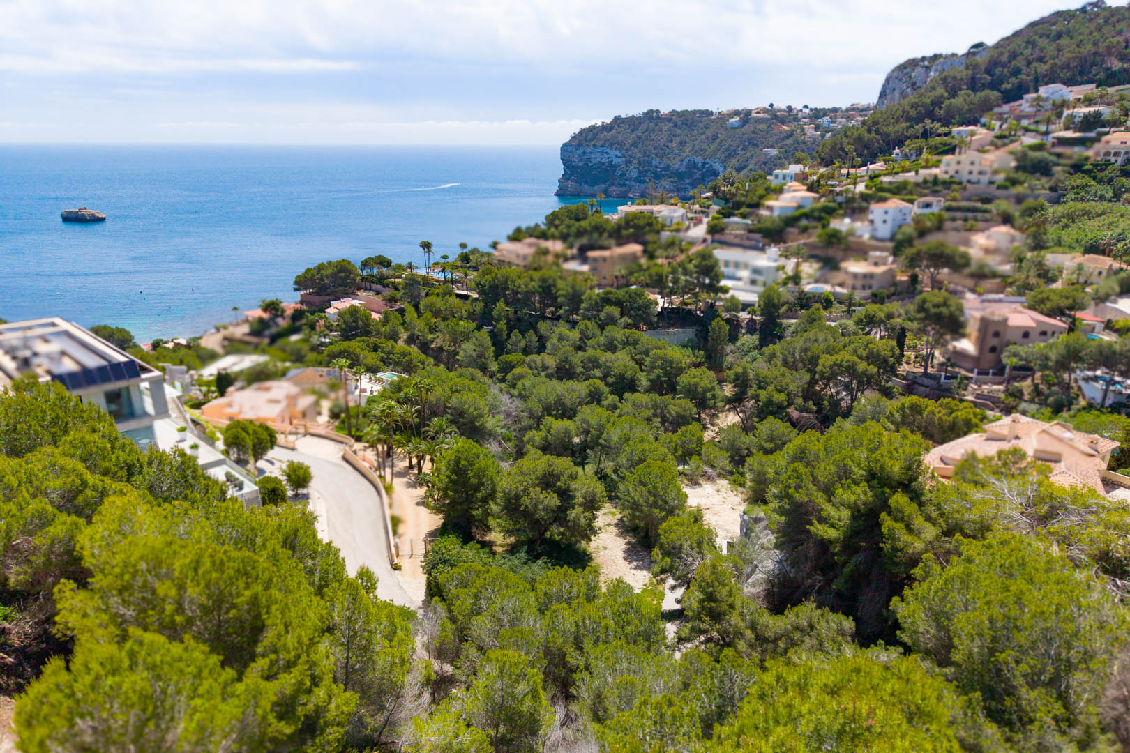 Aerial view of the plot in Mar Azul, Jávea, featuring lush greenery and sea views.