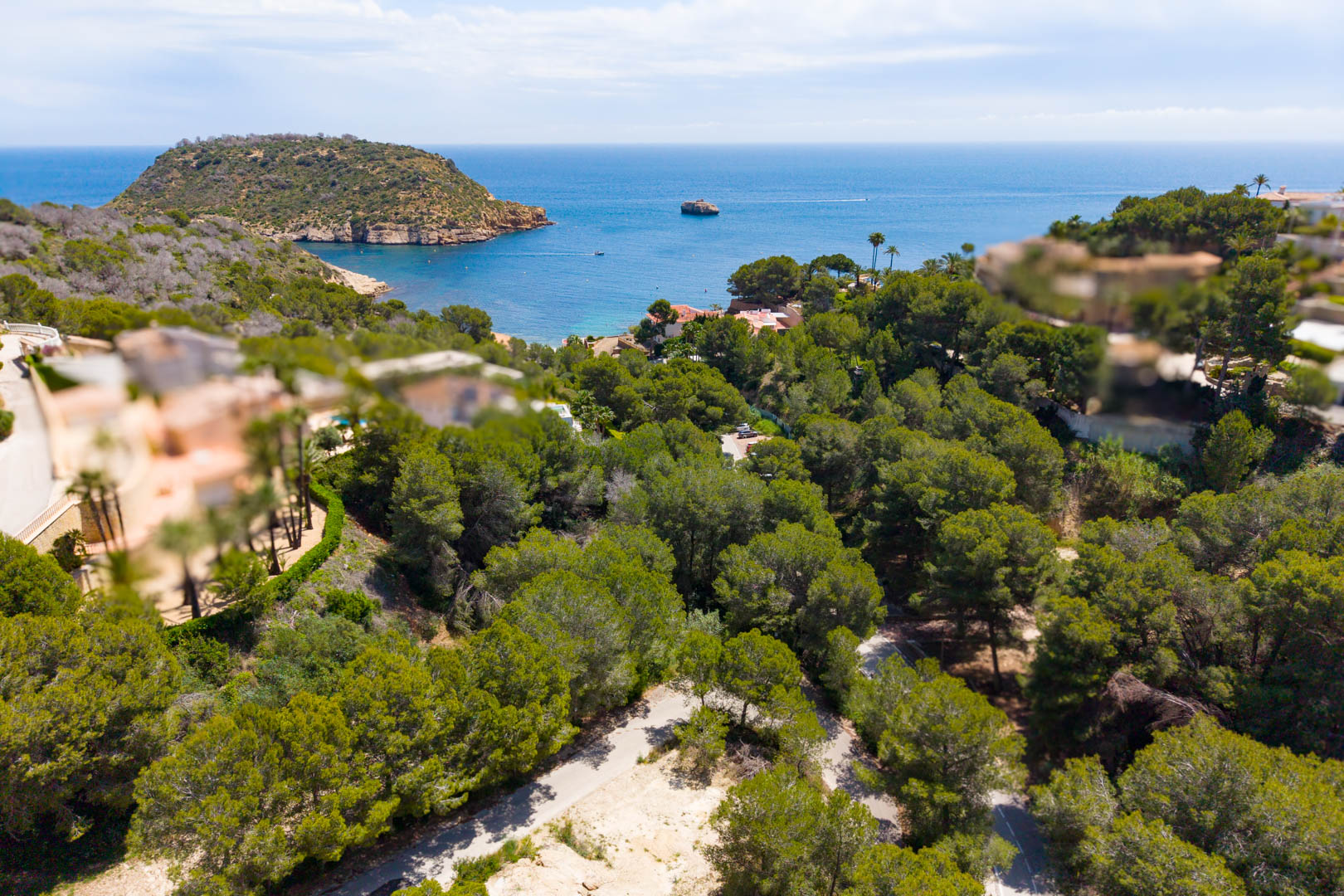 Aerial view of the wooded plot with road access, overlooking the sea and headland in Jávea.