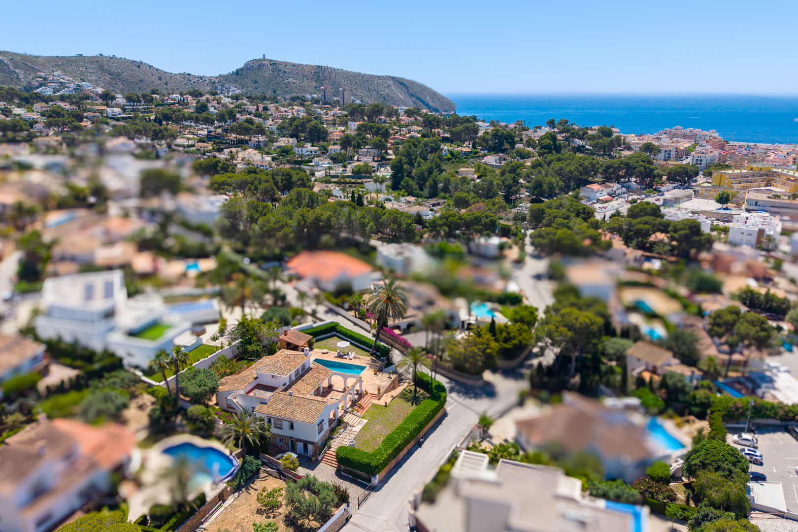 Aerial view of the villa with pool and stone arches, surrounded by Mediterranean greenery.