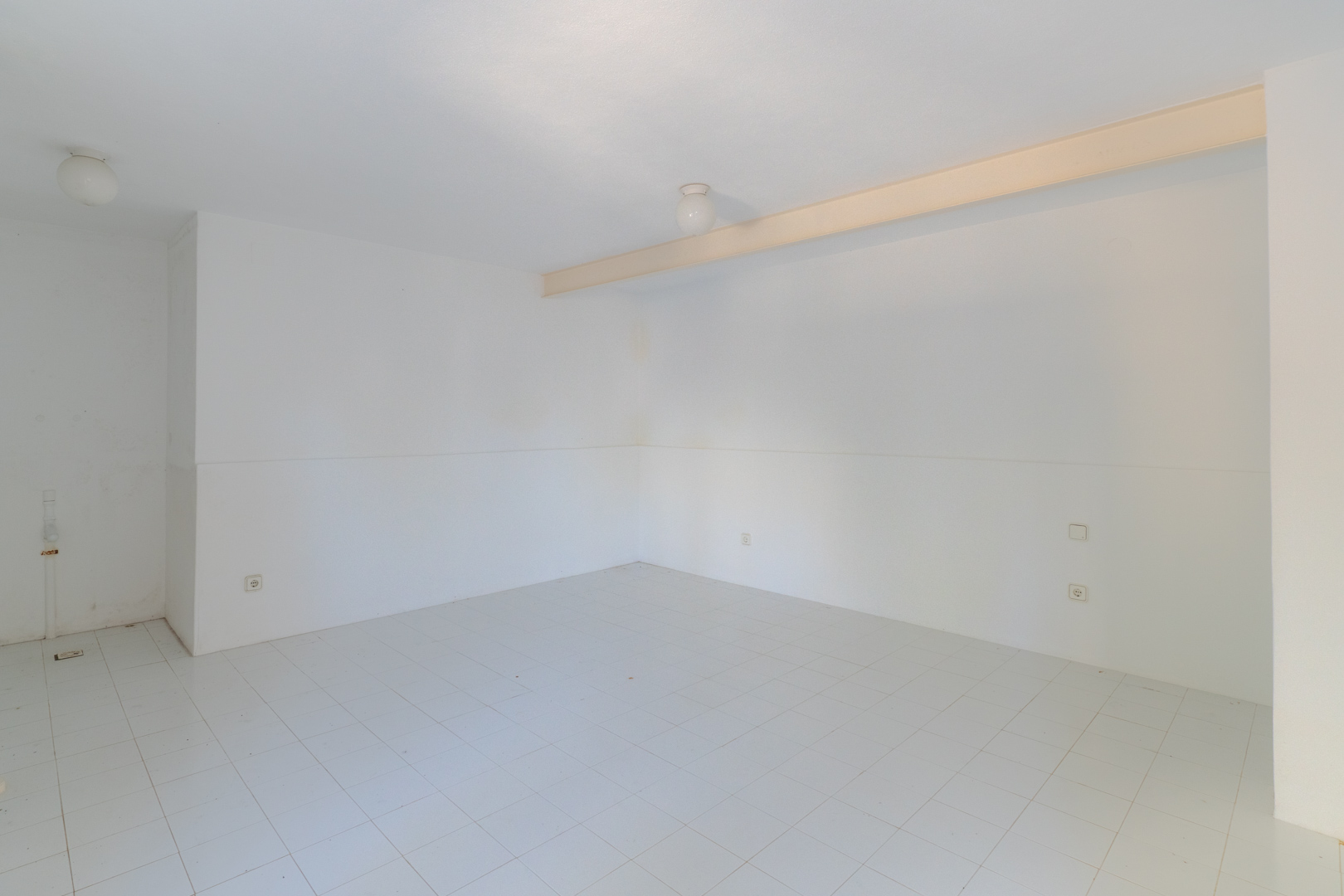 Open space featuring white walls, tiled flooring, and overhead lighting.