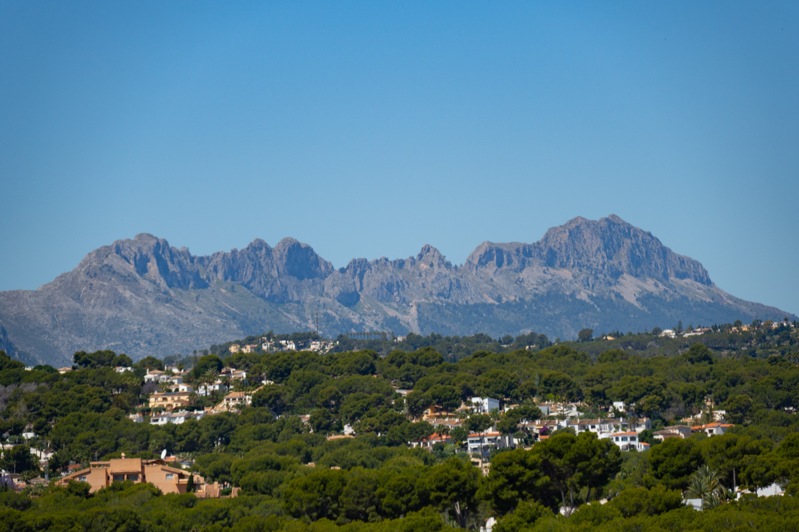 Panoramic views of the Sierra de Bernia from the villa, surrounded by greenery and other residences.