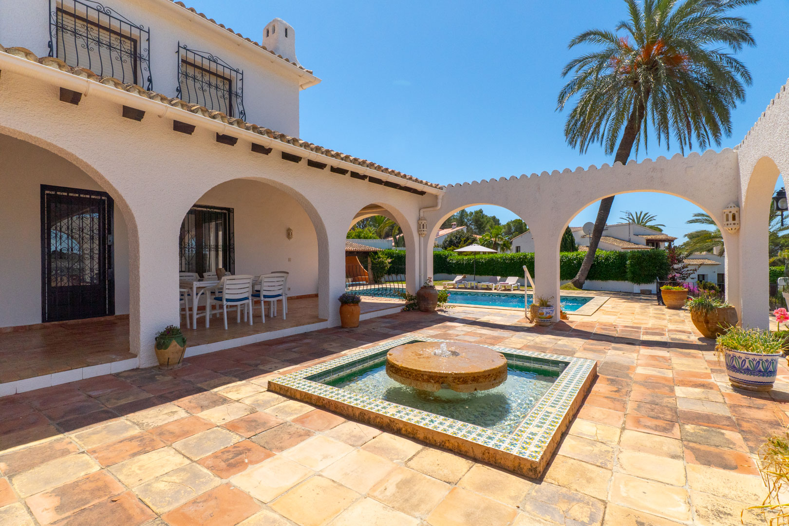 Patio with stone fountain and pool access, in Moraira villa.