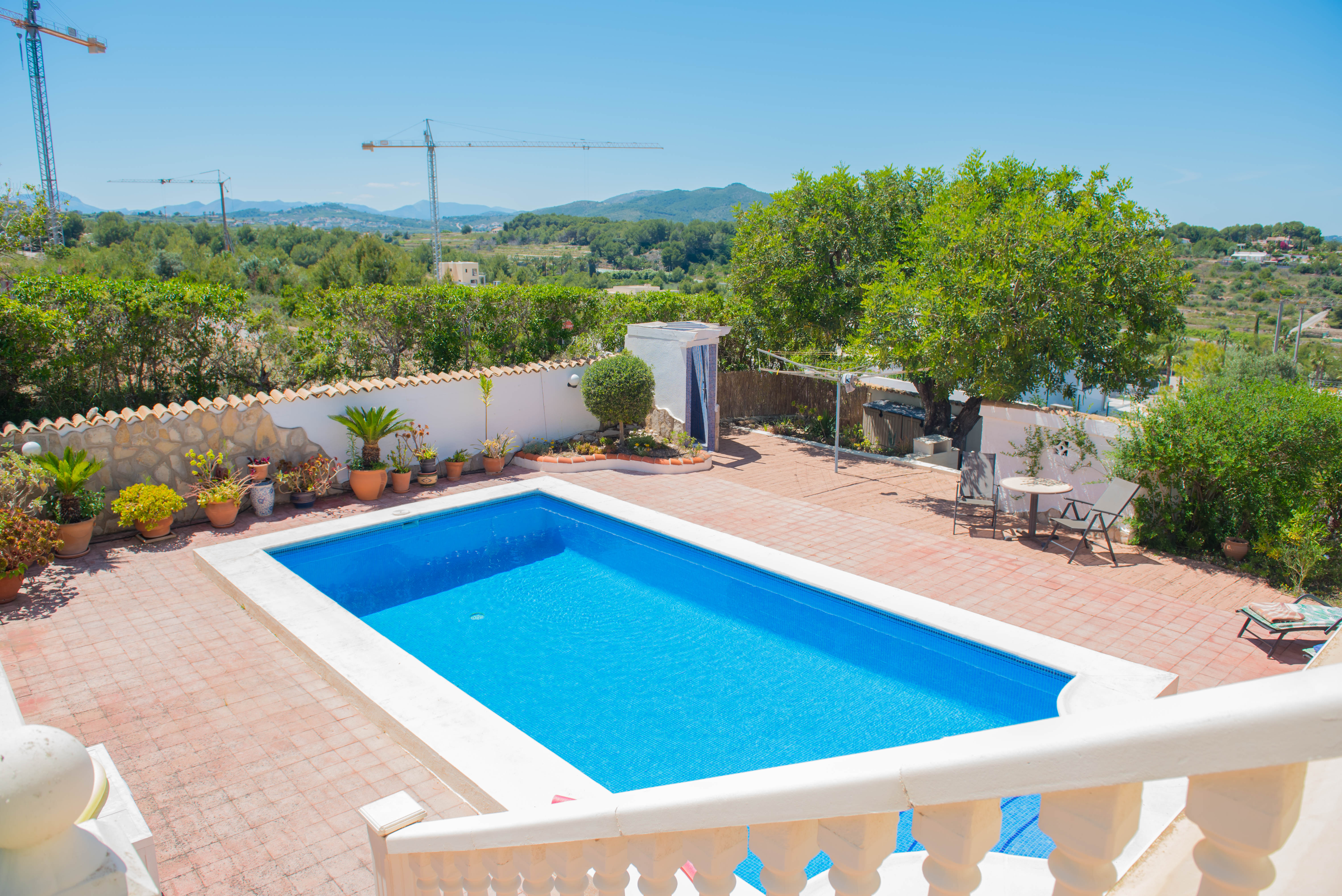 Elevated view of the rectangular pool with white trim and red-tiled patio.