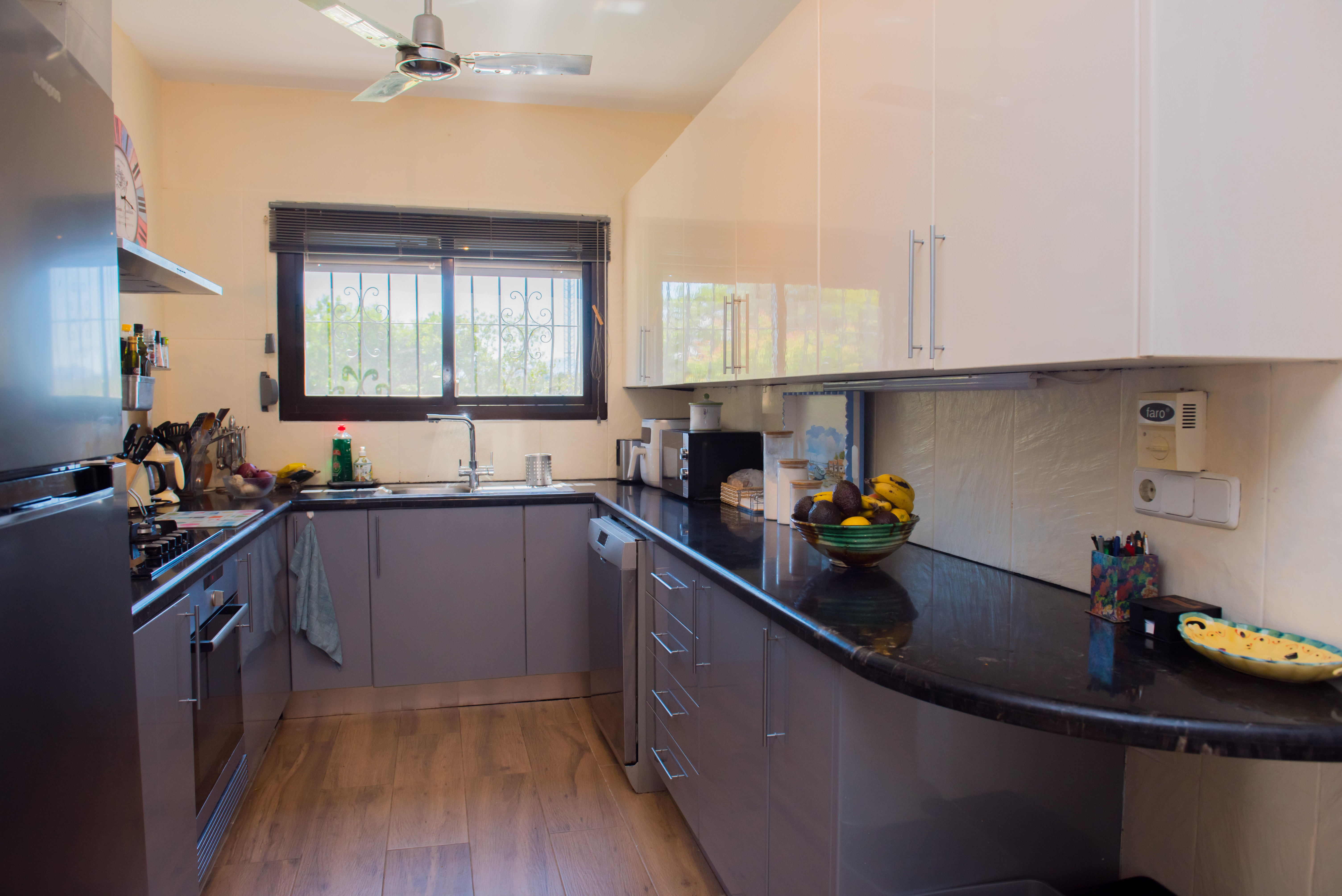 Kitchen featuring black granite countertops and grey cabinets.