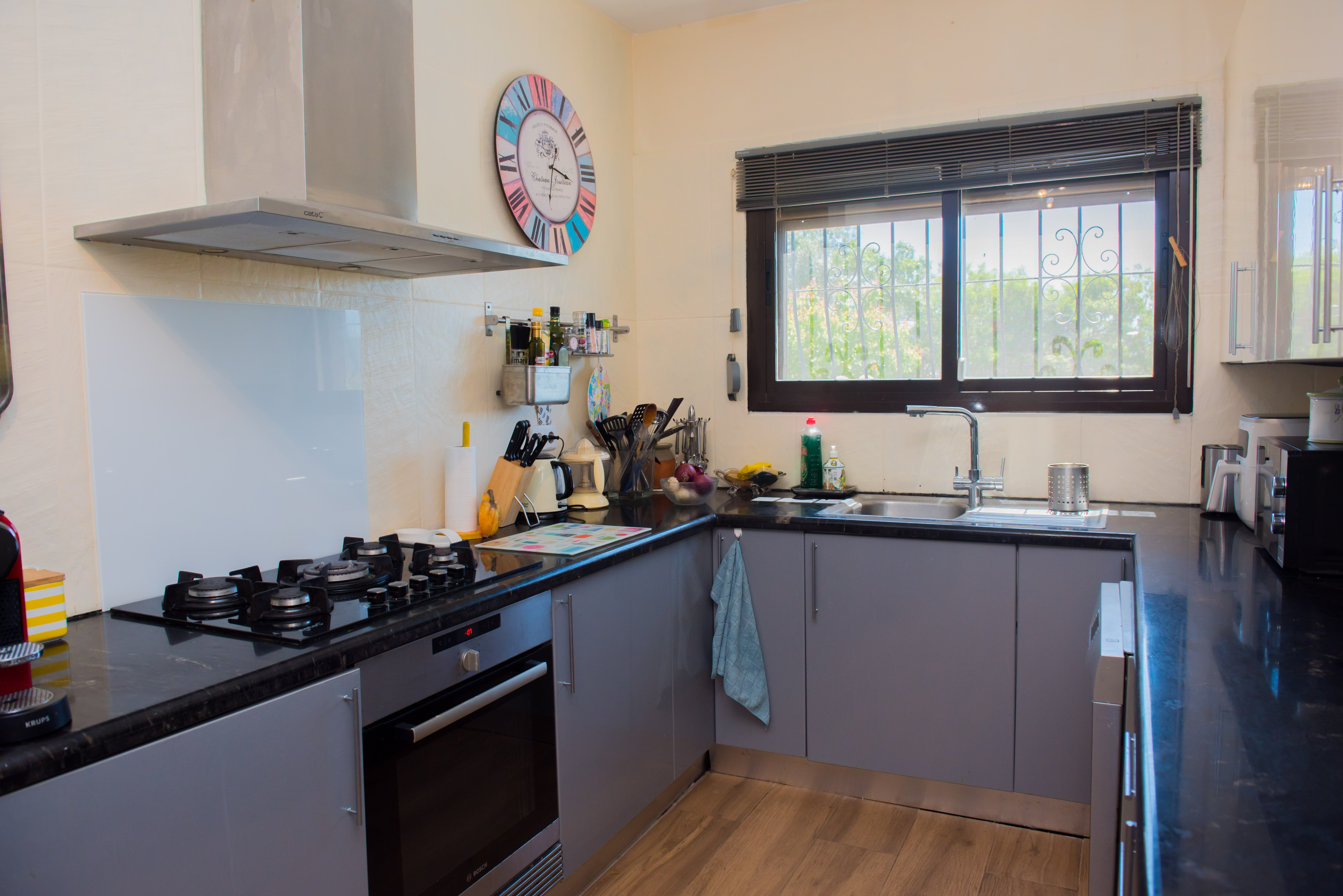 Kitchen featuring black granite countertops, gray cabinets, and stainless steel appliances.