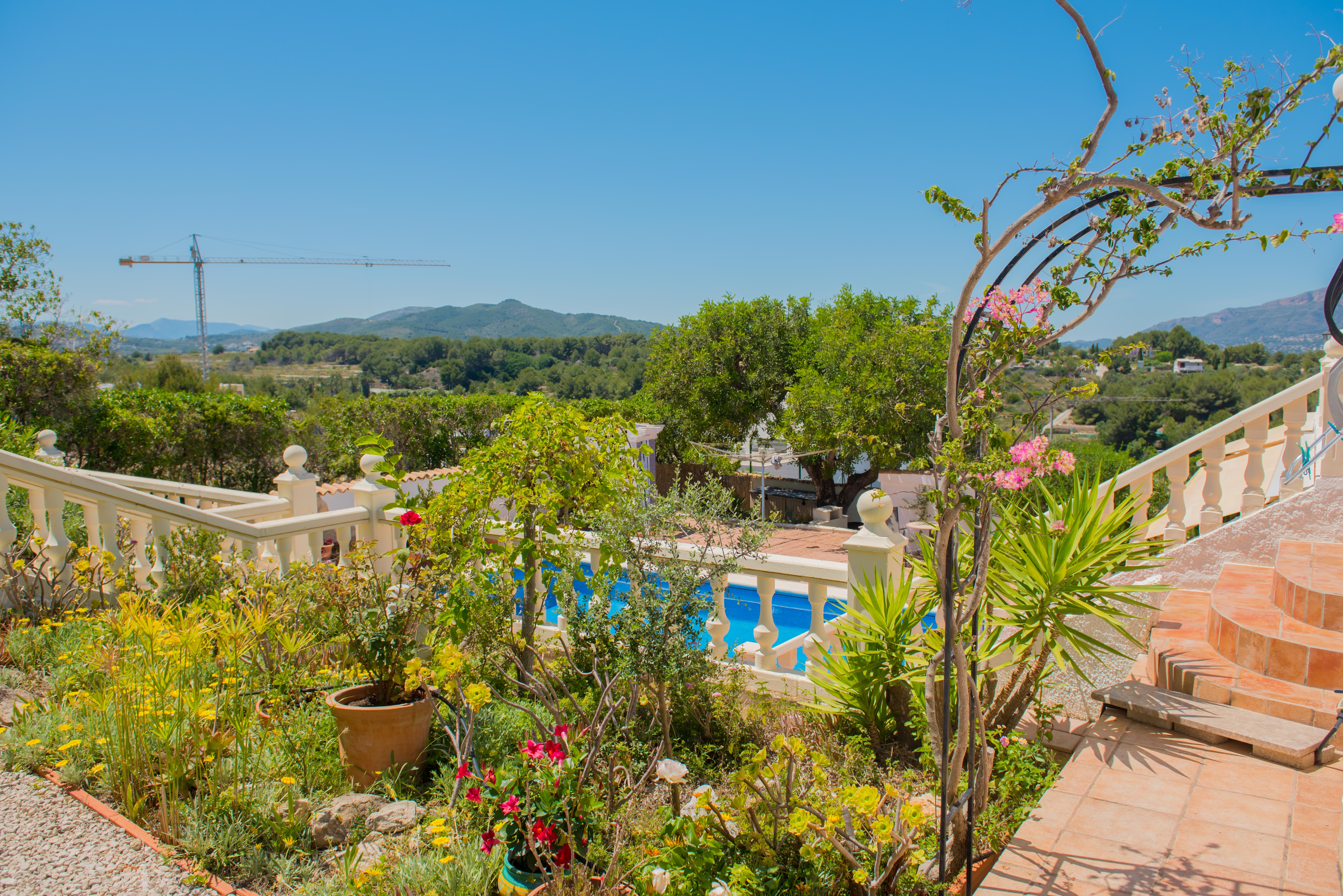 Mediterranean garden with pool view and limestone balustrade.