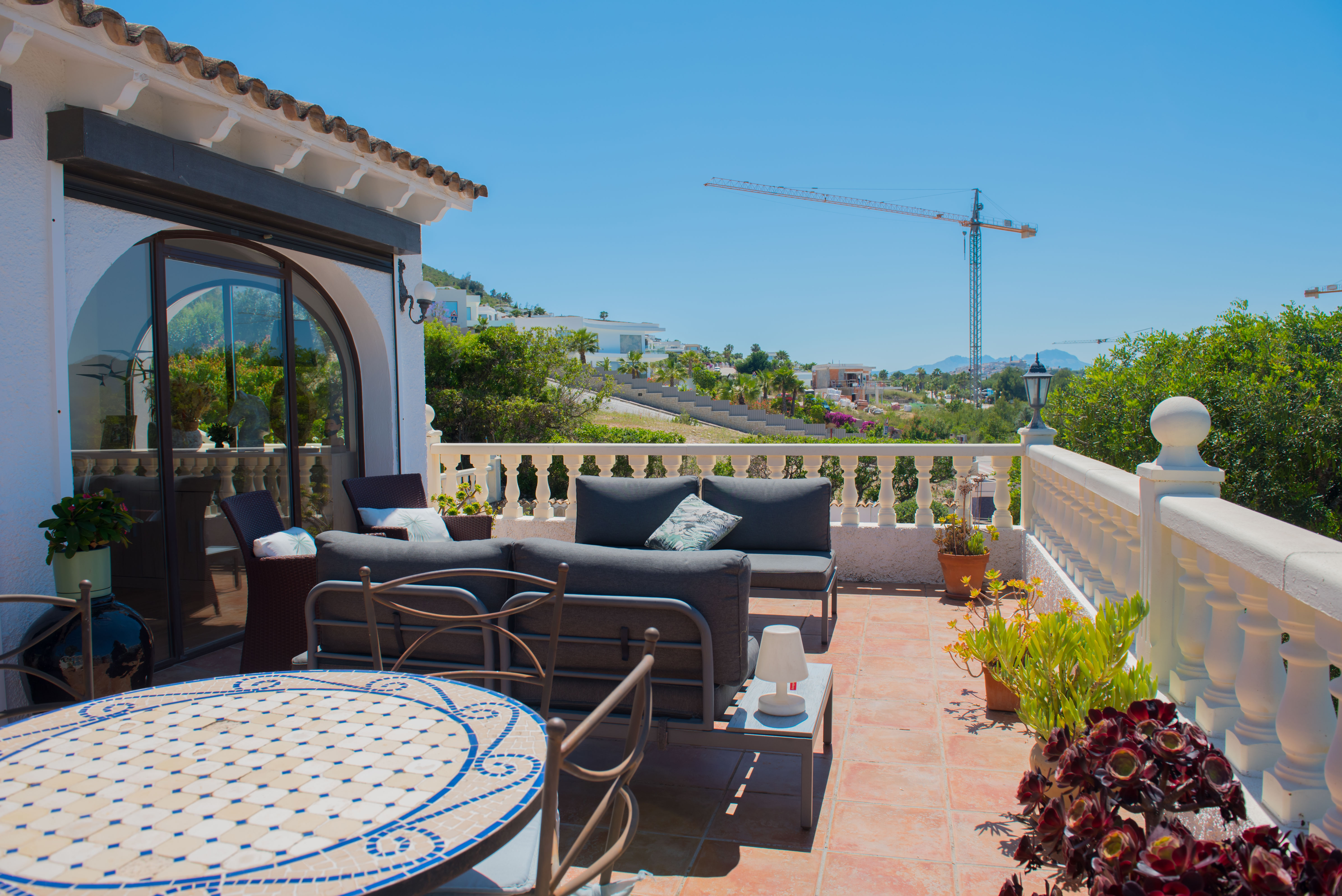 Terrace with terracotta tile flooring, white balustrade and panoramic views.