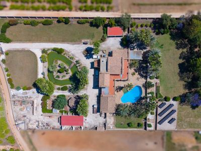 Detailed aerial view of the expansive plot, showcasing the main villa, blue swimming pool, pond with island, and solar panel installation.