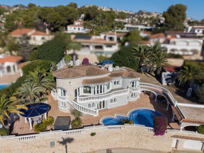 Aerial view of the luxury villa showcasing its distinctive architecture, private pool, multiple terraces with white balustrades, and lush Mediterranean garden.