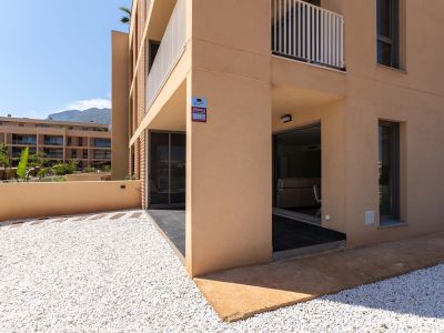 Ground floor exterior featuring a modern ochre facade. Includes a private white gravel garden and a covered terrace with direct access to the interior, offering mountain views.