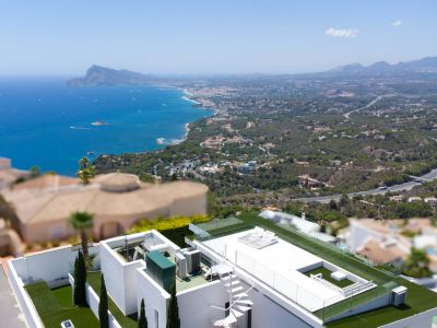 Aerial view of the villa's rooftop terrace featuring a white spiral staircase, artificial grass, glass railings, and expansive views of the Mediterranean Sea and coastal landscape.