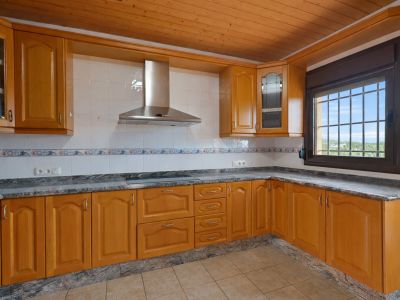 Equipped kitchen featuring wooden cabinetry, granite countertops, and a wooden plank ceiling. Window with security bars offers exterior views.