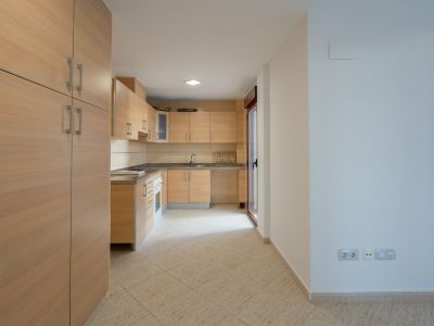Equipped kitchen with light wood cabinetry, granite countertops, and tiled flooring. Features a glass door leading to a patio.