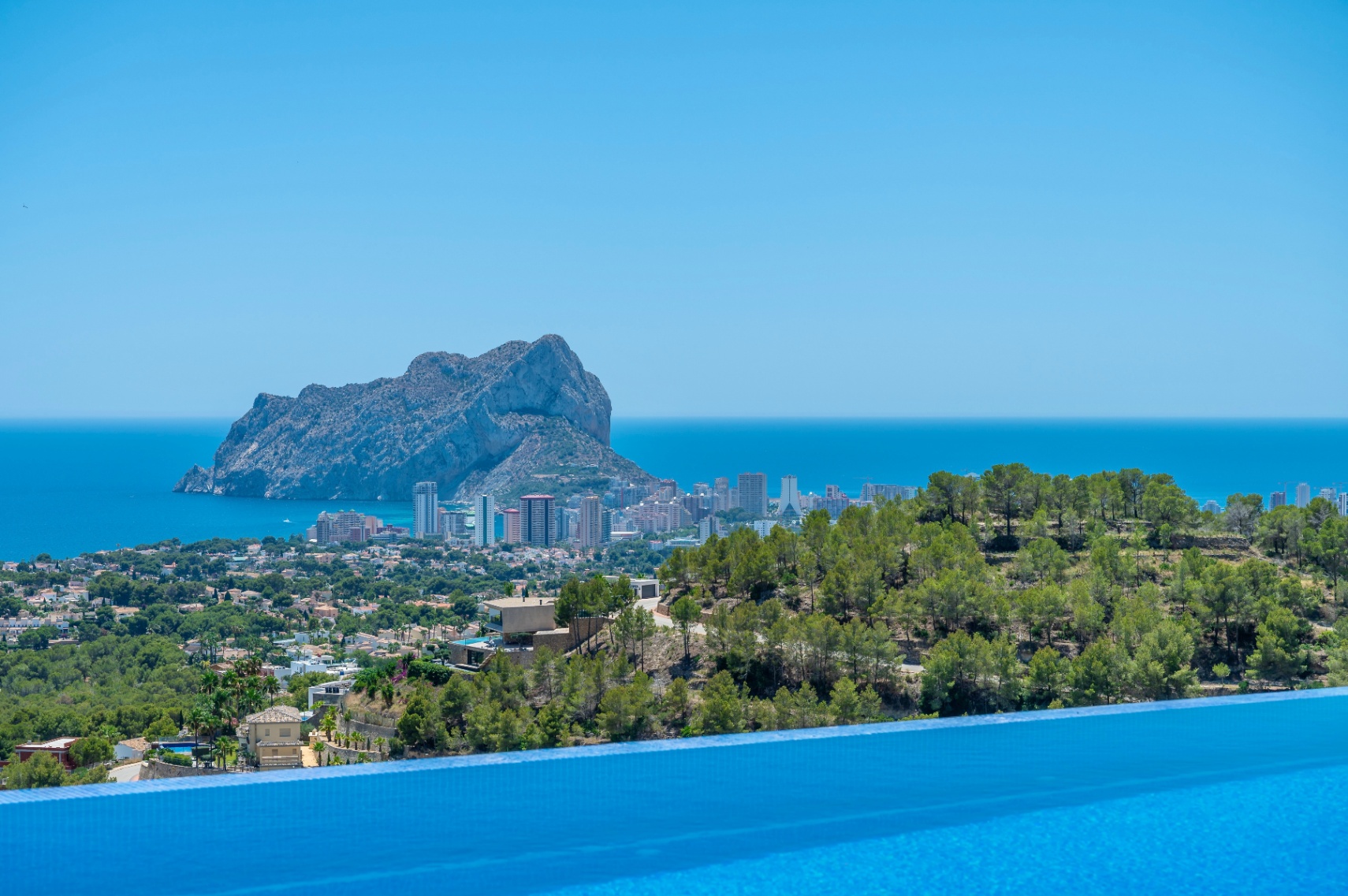 Infinity pool edge framing panoramic views of the Mediterranean Sea, Calpe, and the iconic Peñon de Ifach.