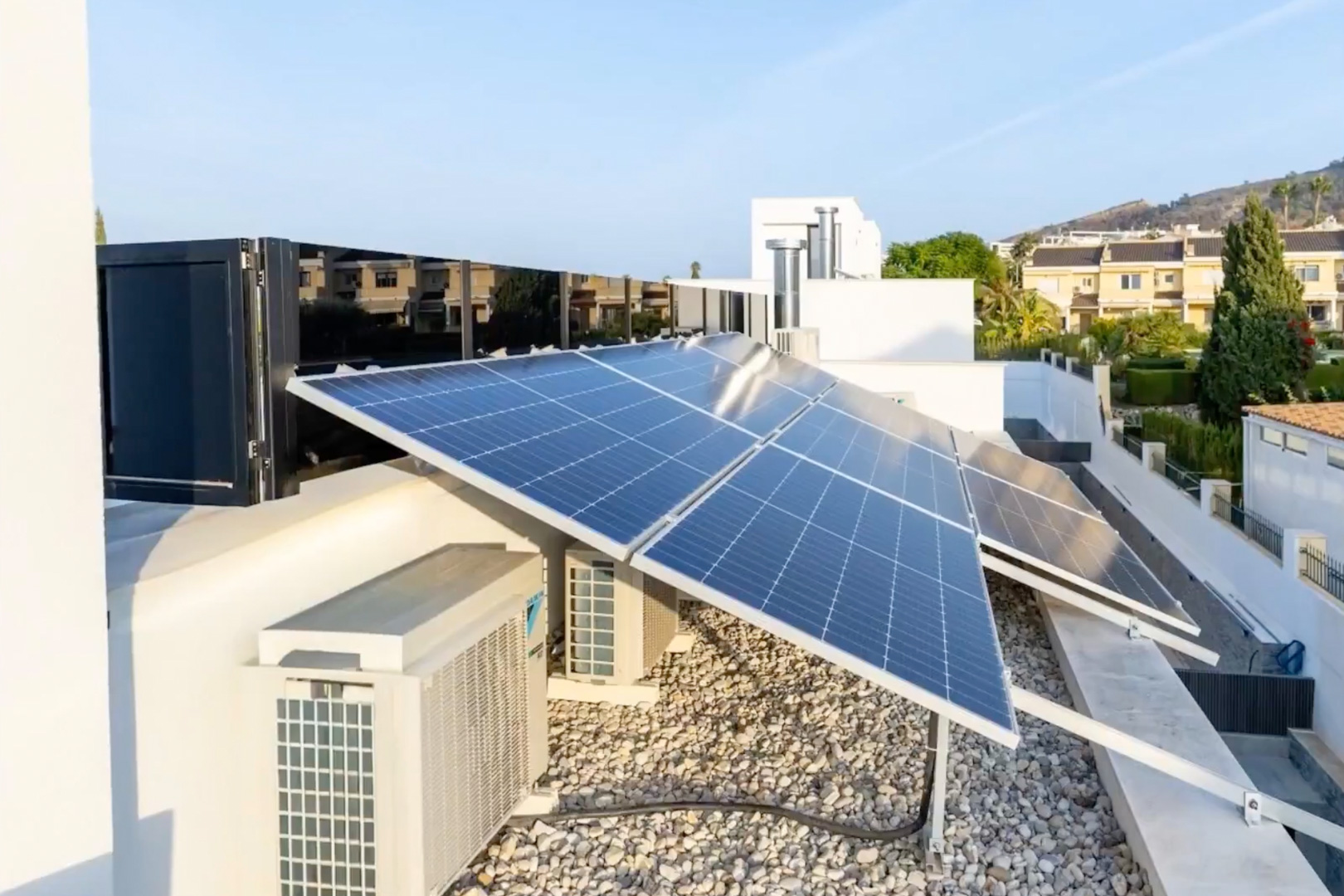 Extensive photovoltaic solar panel system on the roof. Climate control units and a light gravel surface complete this high-efficiency installation.