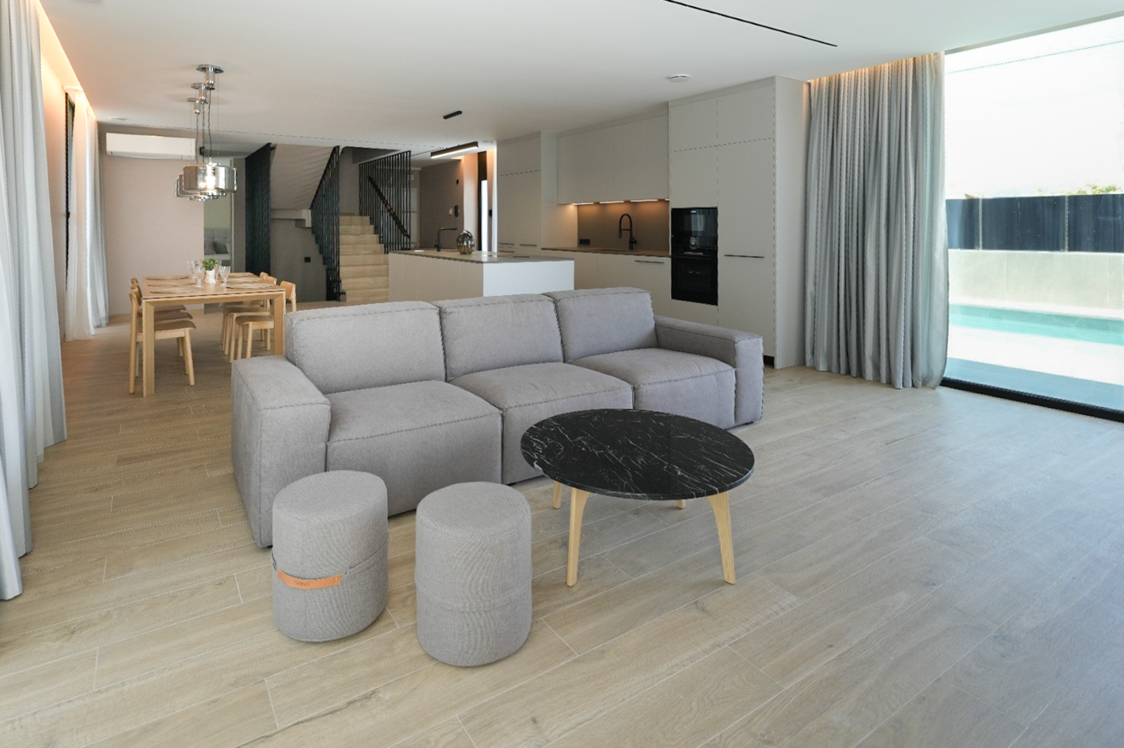 Open-plan living and dining area featuring a modular sofa, marble coffee table, integrated kitchen, and large windows overlooking the outdoor pool.