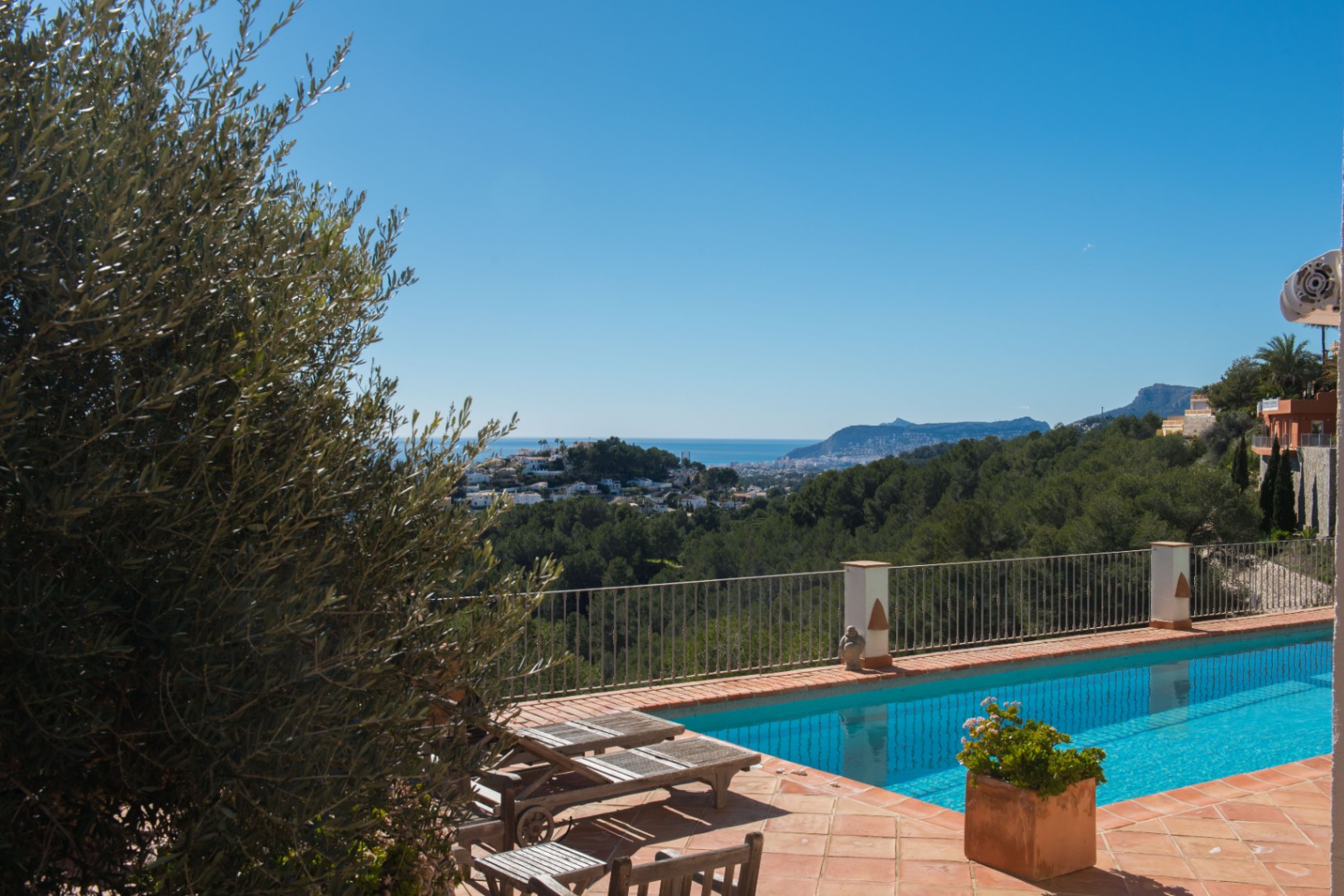 Terrace with terracotta tiling and a rectangular pool, offering panoramic views of the Mediterranean coastline and the Peñón de Ifach beyond the pine forest.