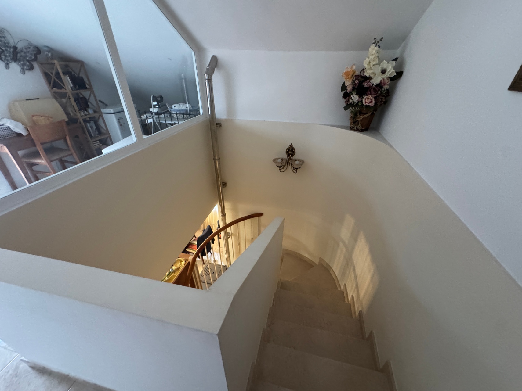 Detail of the interior staircase with wooden railing and stone steps.