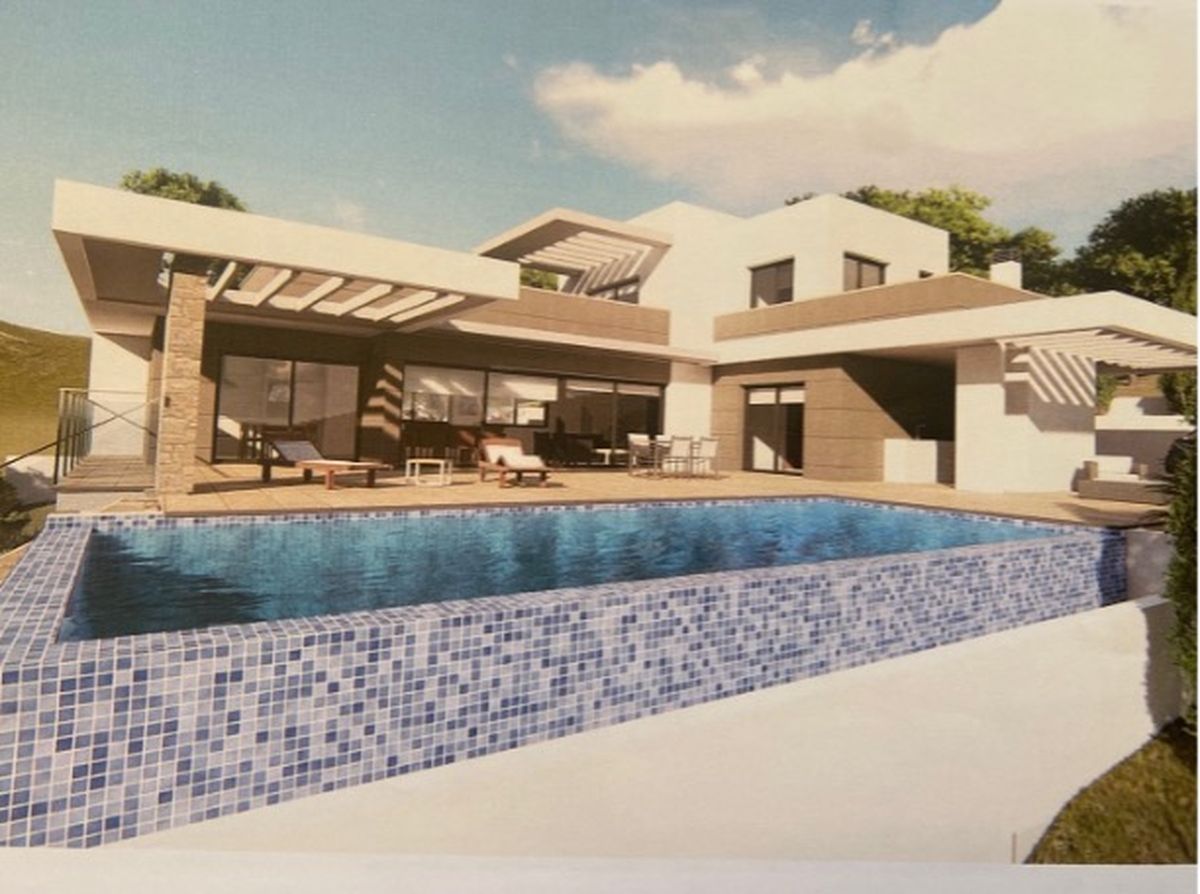 Modern villa exterior featuring an infinity pool with blue mosaic tiles, a spacious sun terrace, and contemporary architectural lines with stone accents.