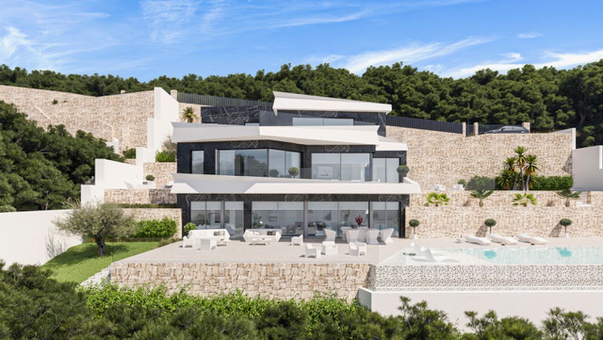 Modern multi-level villa featuring a white and dark stone facade, expansive glass windows, and terraced stone walls integrated into a lush hillside landscape.