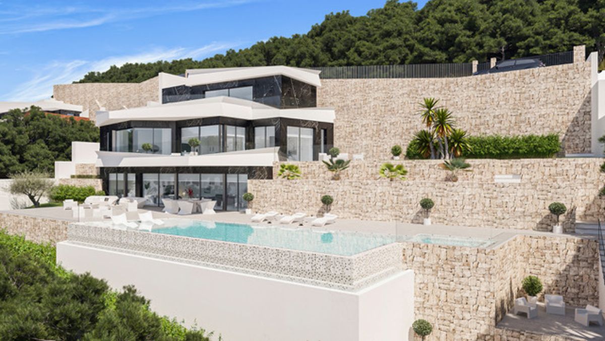 Modern multi-level villa featuring an infinity pool, stone-clad terraced walls, and expansive glass facades integrated into a lush hillside landscape.