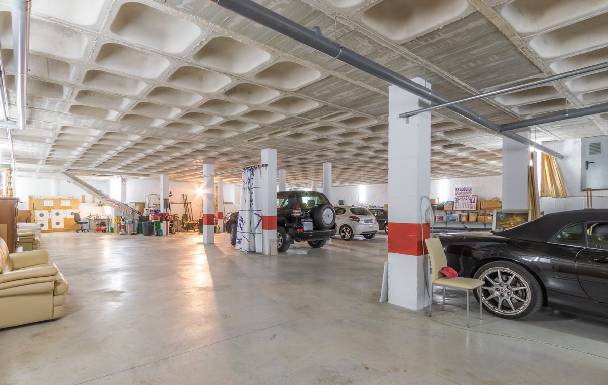 Spacious underground garage featuring a waffle slab concrete ceiling, structural columns with red markings, and ample room for multiple vehicles and storage.