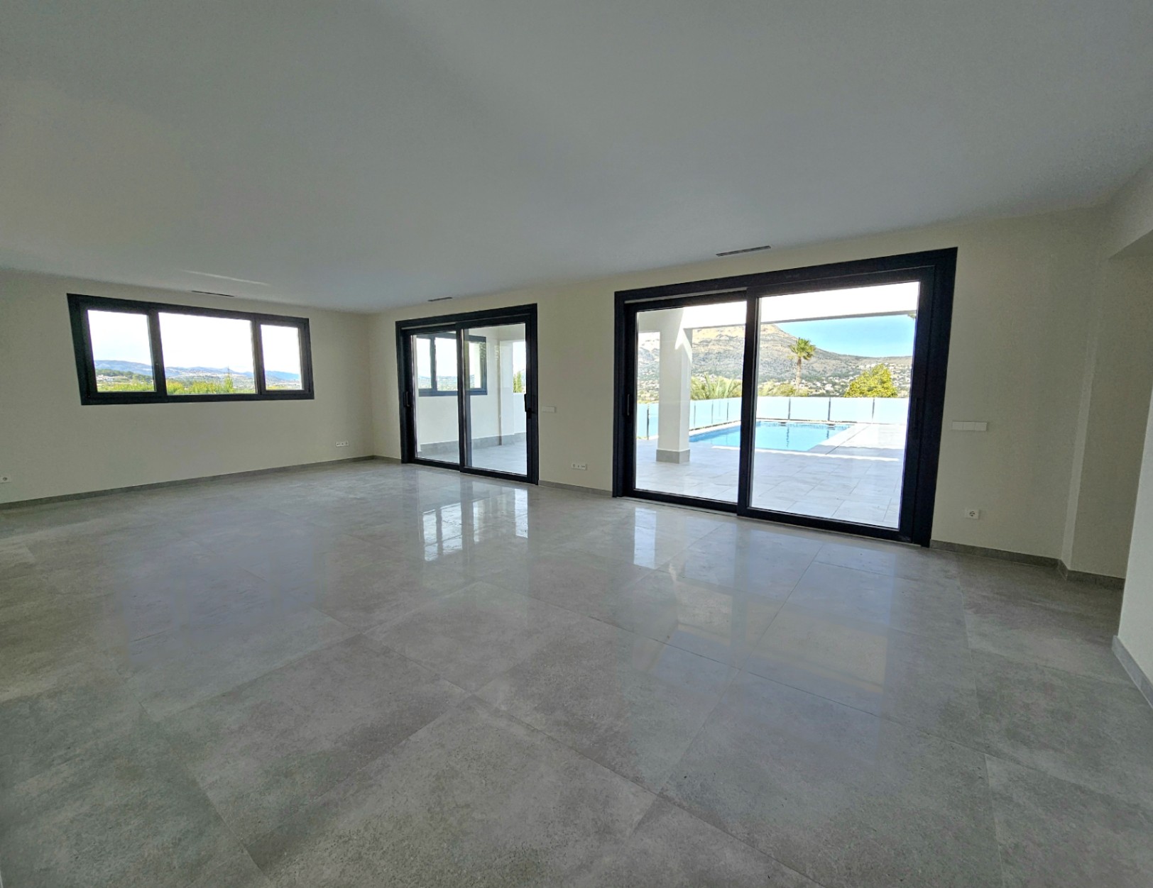Expansive living room featuring tile floors and access to the terrace with pool and Montgó views.