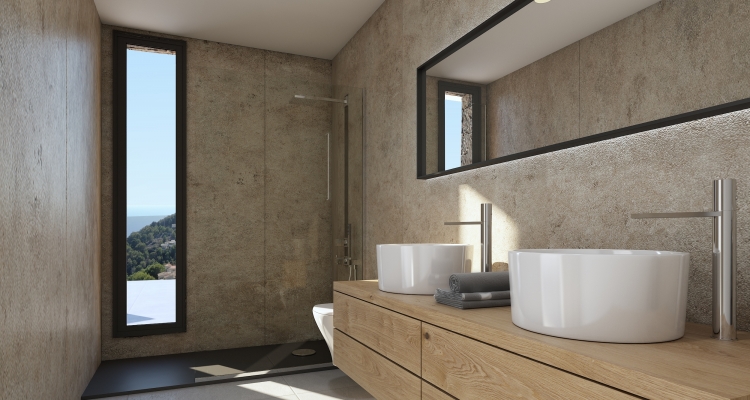 Modern bathroom featuring double vessel sinks on a wooden vanity, stone-textured walls, and a walk-in shower. A vertical window captures the coastal landscape.