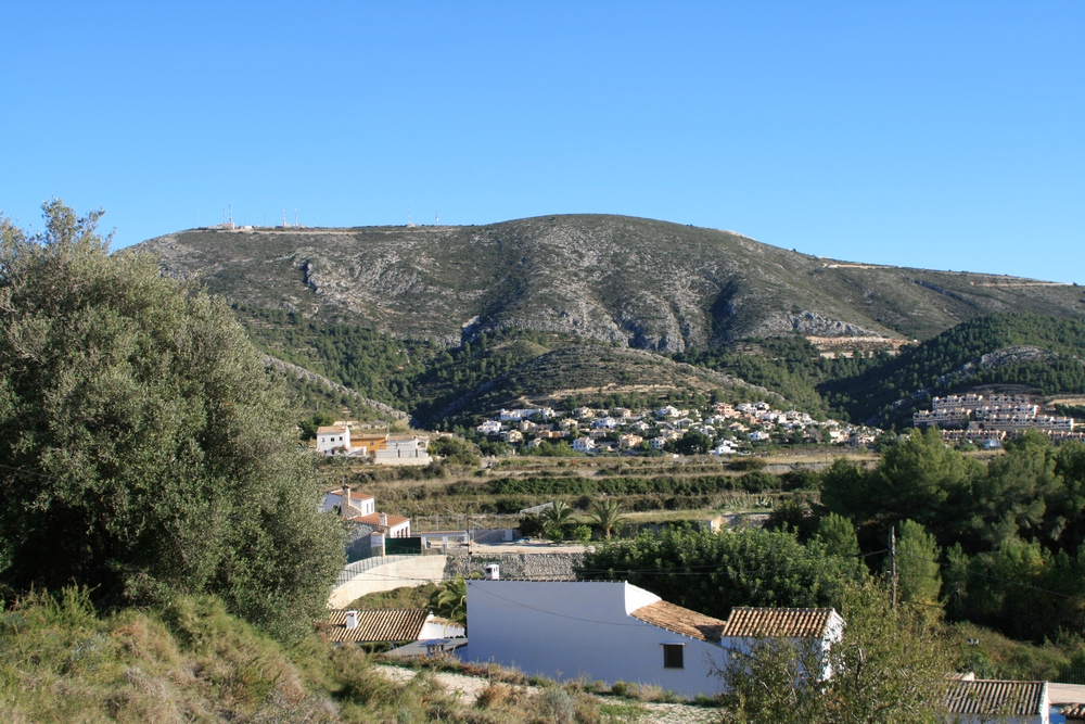 View of the Benitachell rural landscape with tiled-roof houses and a mountain backdrop.