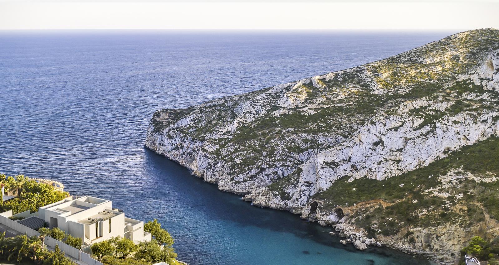 Aerial perspective of the villa situated above the Granadella cove, featuring panoramic views of the Mediterranean Sea and the white limestone cliffs.