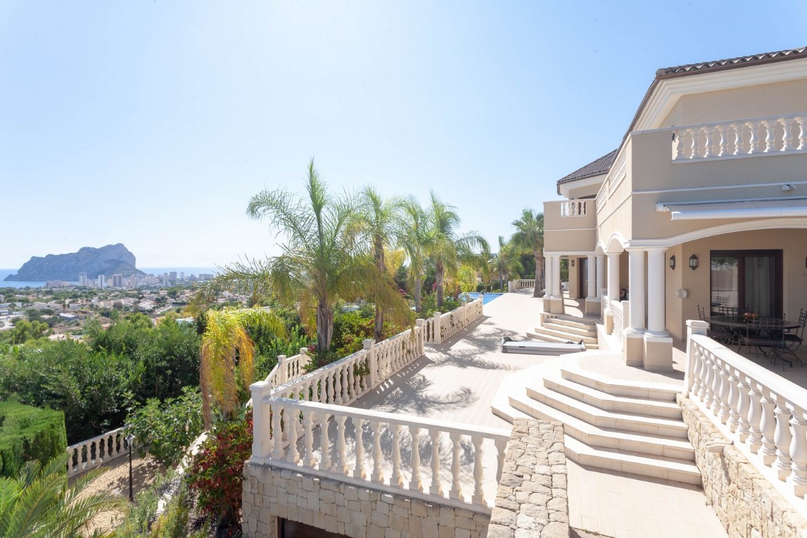 Spacious outdoor terrace with classic white balustrades and stone walls, featuring panoramic views of the Peñón de Ifach and the Mediterranean coastline.