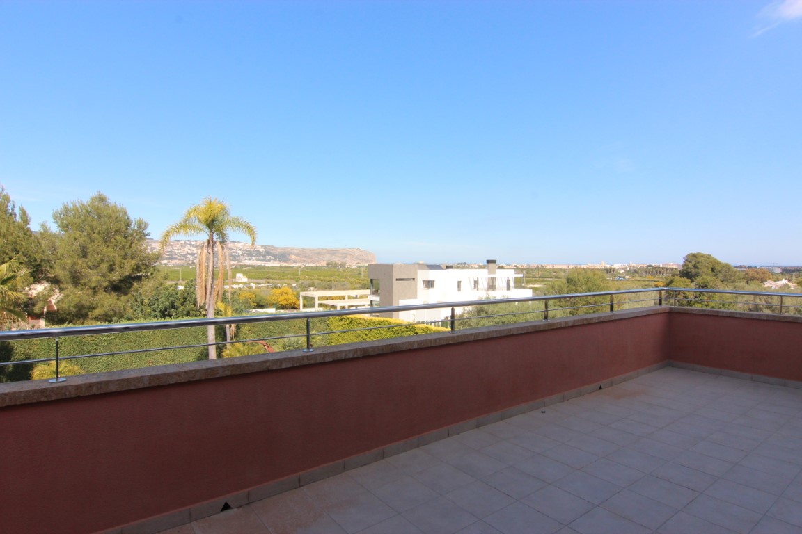 Upper-floor terrace featuring stainless steel railings and stone capping, offering expansive views of the surrounding valley and mountains.