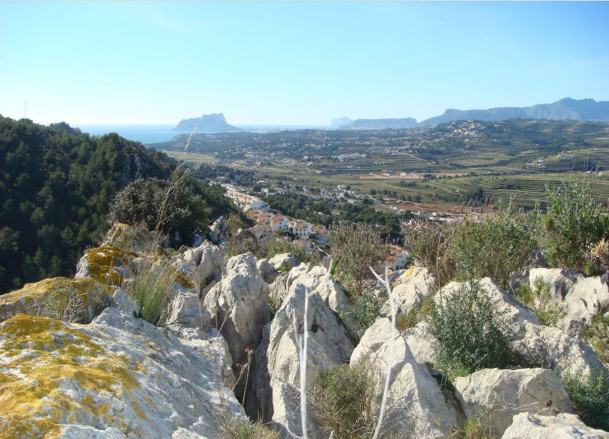 Panoramic views from the elevated plot towards the Peñón de Ifach and the Mediterranean Sea, featuring natural rock formations and local flora.
